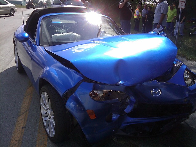 A blue car with a bent hood